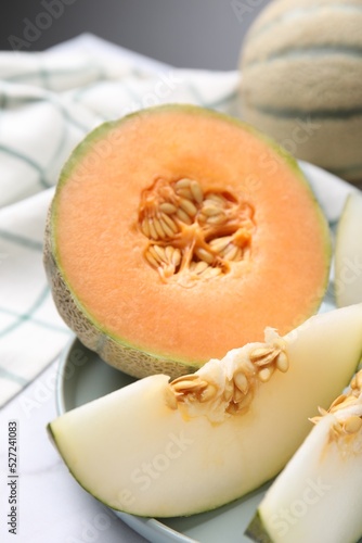 Tasty colorful ripe melons on white marble table, closeup