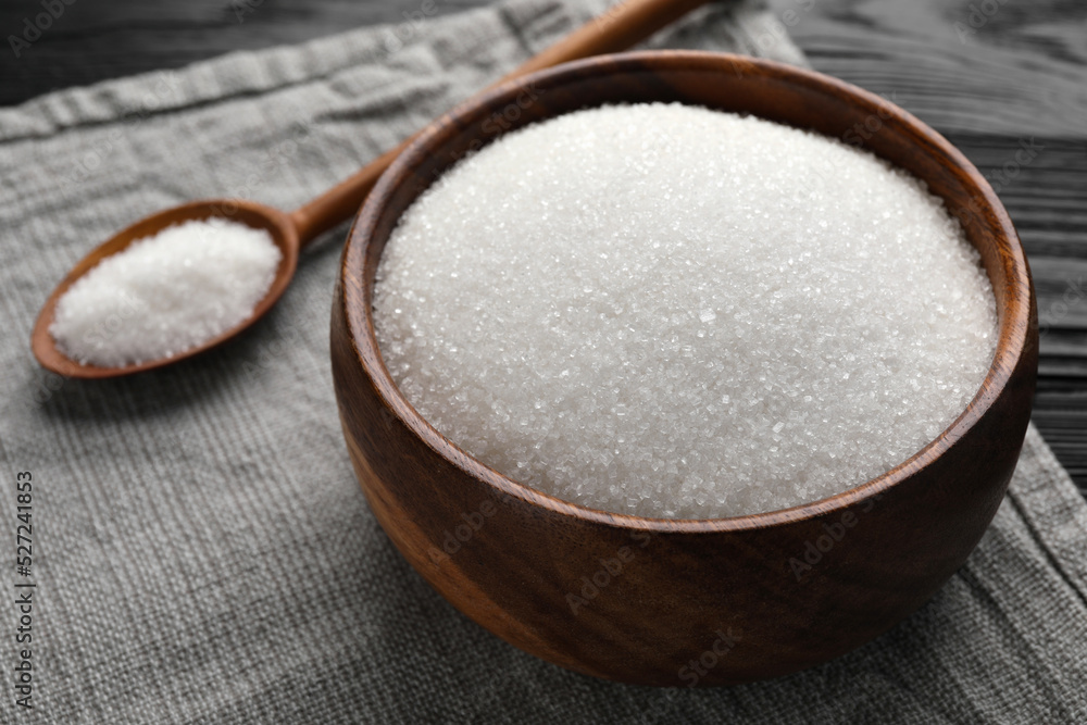 Granulated sugar in bowl and spoon on towel, closeup Granulated sugar in bowl and spoon on towel, closeup