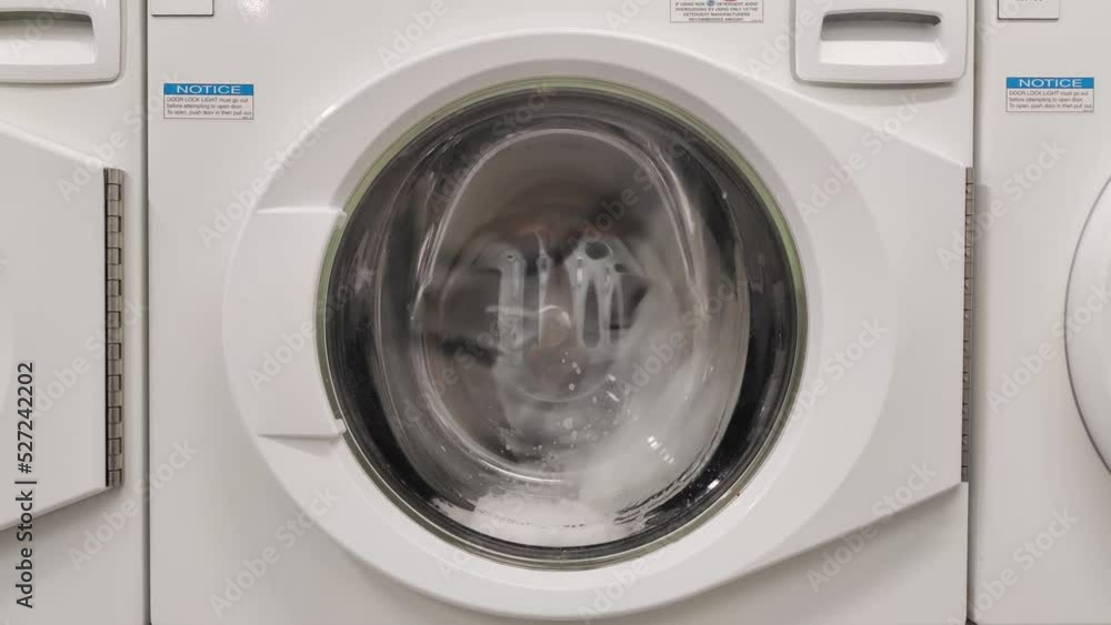 Close-up video of spinning drum washing machine | Washing clothing in domestic washing machine in home Close-up video of spinning drum washing machine | Washing clothing in domestic washing machine in home