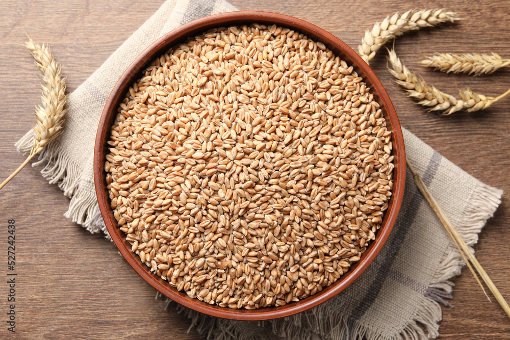 Wheat grains and spikes on wooden table, flat lay Wheat grains and spikes on wooden table, flat lay