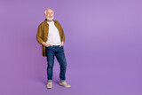 Full body photo of cheery granddad grey hair hands pockets dressed trendy yellow checkered shirt isolated on lilac purple color background