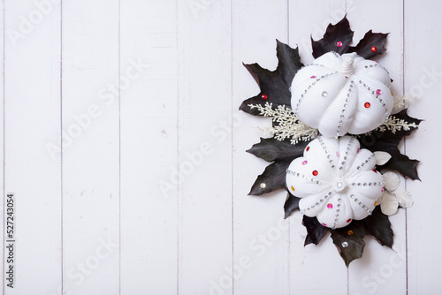 Creative autumn flat lay composition with textile decorative pumpkins and mapl leaves top view decorated with rhinestones photo