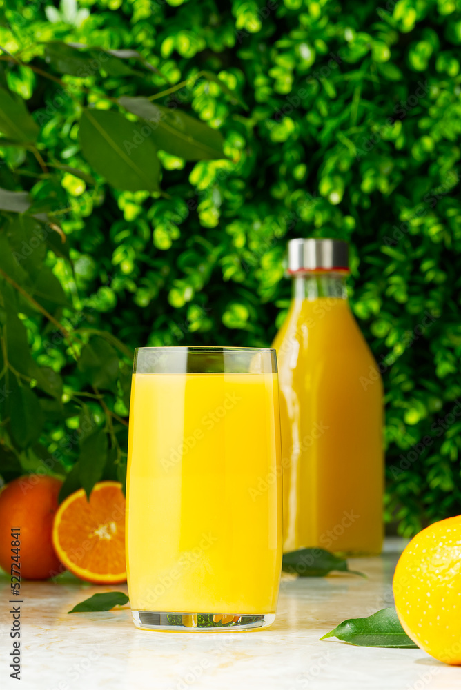 Glass of orange juice and orange juice bottles. Glass and bottle of organic tropical juice Glass of orange juice and orange juice bottles. Glass and bottle of organic tropical juice