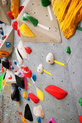 Artificial rock climbing bouldering wall showing various colored grips.