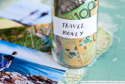 Travel in Australia to coastal destination concept - money in jar on map with holiday photos