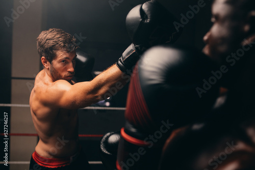 Photography Muscular athlete striking at his opponent during a boxing fight