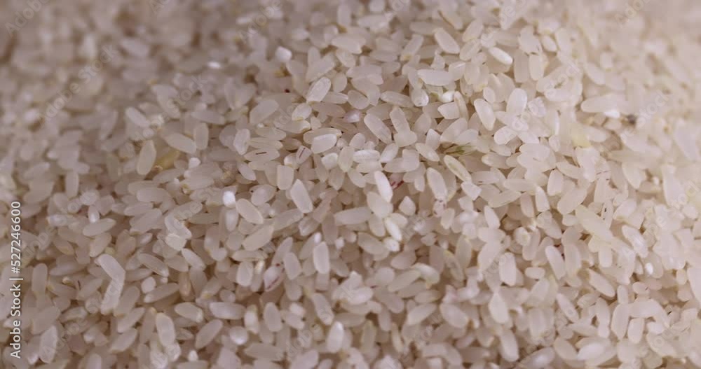 a pile of white rice spinning in a circle, white uncooked rice grains on the table during cooking a pile of white rice spinning in a circle, white uncooked rice grains on the table during cooking