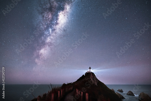 The Milky Way rising above Nugget Point lighthouse, Southland. photo