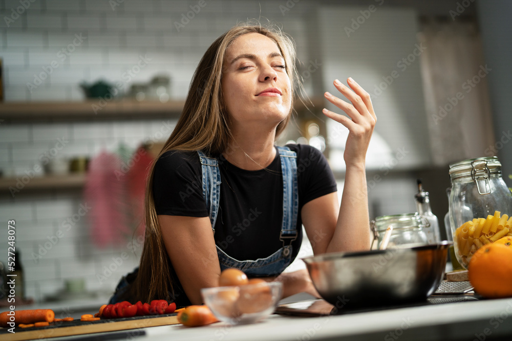 Young woman in kitchen. Beautiful woman making delicious food