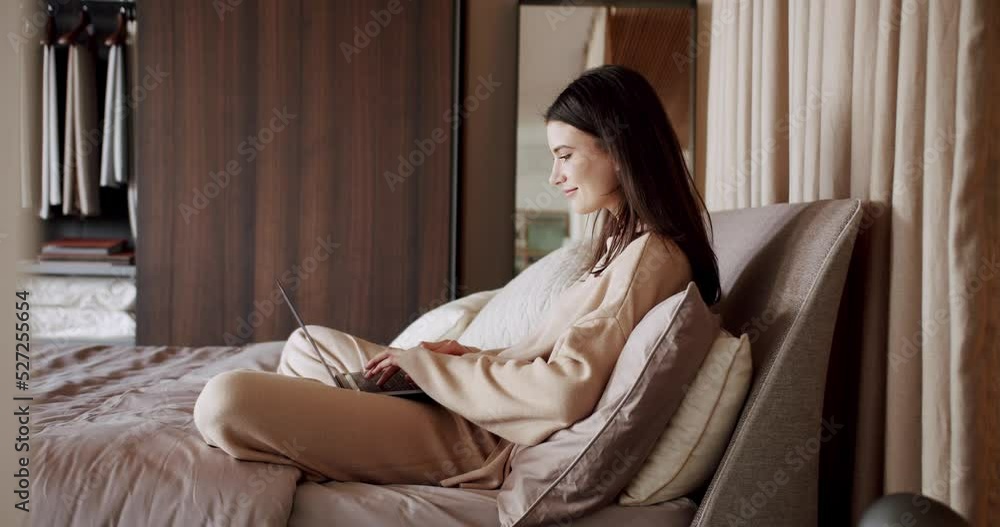 Woman is working with a laptop in her bedroom, Work from home concept, Self quarantine, coronavirus. Young beautiful woman using laptop apps wear pyjama sitting in cozy bed in the morning. Woman is working with a laptop in her bedroom, Work from home concept, Self quarantine, coronavirus. Young beautiful woman using laptop apps wear pyjama sitting in cozy bed in the morning.