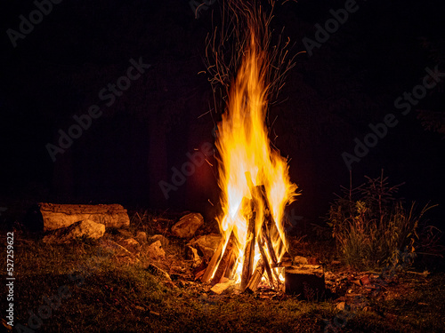 logs burning in camp fire in darkness