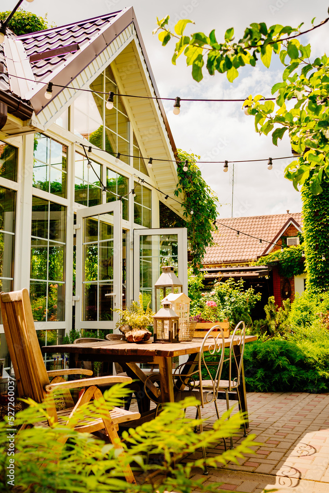 wooden table in the courtyard of the country house with retro decor elements.