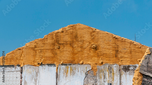 Espuma dorada aislante en muro medianero en perfil de tejado en edificio