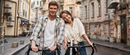 Young smiling caucasian couple poses with bicycles