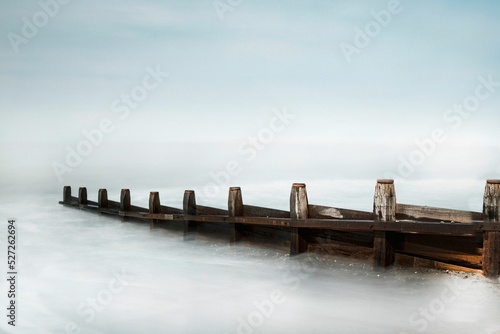 View of wooden fences in frozen sea in Tywyn photo