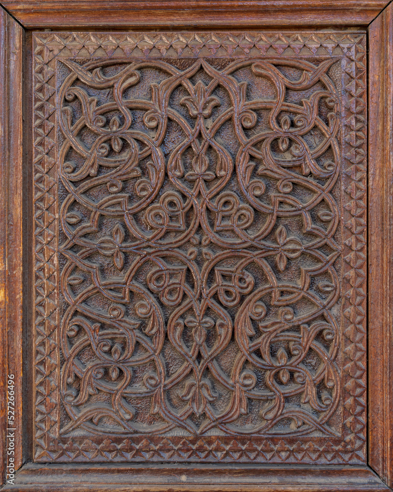 Closeup view of beautiful traditional wood carving on ancient door with intricate floral and geometric design, Istaravshan, Sughd region, Tajikistan