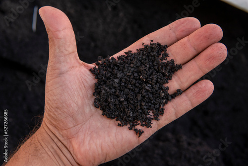 Recycled rubber in hand. Rubber crumb obtained in the process of recycling used car tires used for flooring sports and playgrounds. photo