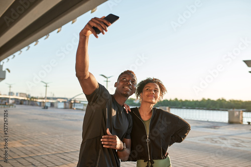 Black sports couple taking selfie on mobile phone