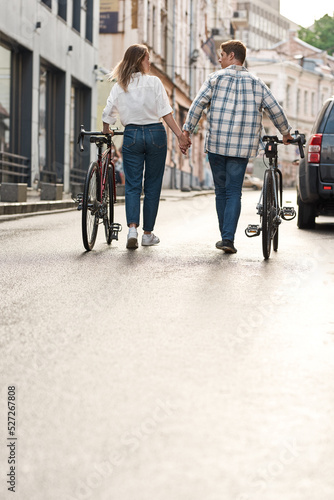 Couple holding hands and walking with bicycles