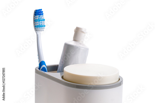 Single new blue handle toothbrush and a tube of toothpaste in plastic holder isolated on white background with clipping path.