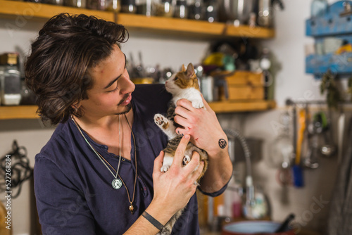 young adult caucasian man holding his cat