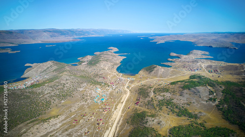 Lake Baikal from the air. View of the coast and the bays of the Small Sea, tourist camps and wooden hotel houses.