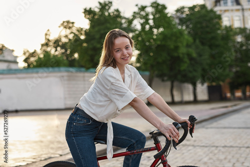 Side of smiling european girl stand with bicycle © Svitlana