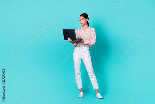 Full size photo of cute young japanese girl seo create social media plan wear stylish smart casual outfit isolated on cyan color background