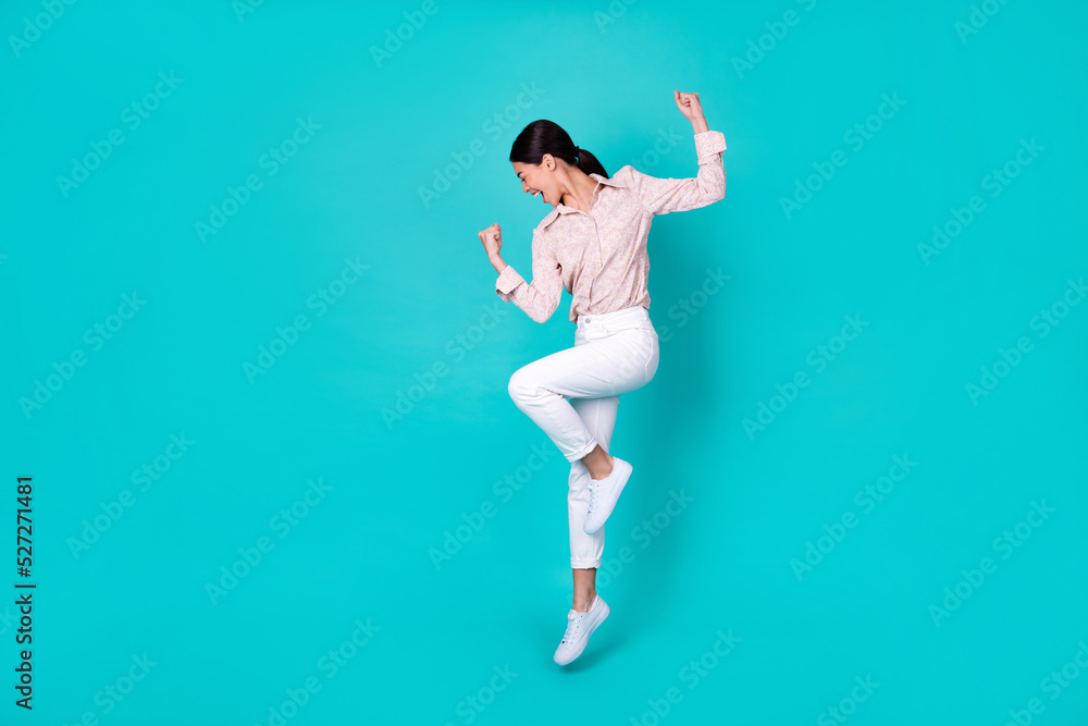 Full body photo of young japanese woman raise fists achieve goal dressed trendy smart casual outfit isolated on aquamarine color background