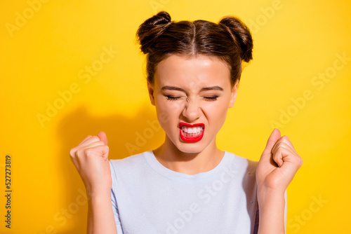 Photo of pretty angry girl dressed white shirt showing teeth rising fists closed eyes isolated yellow color background