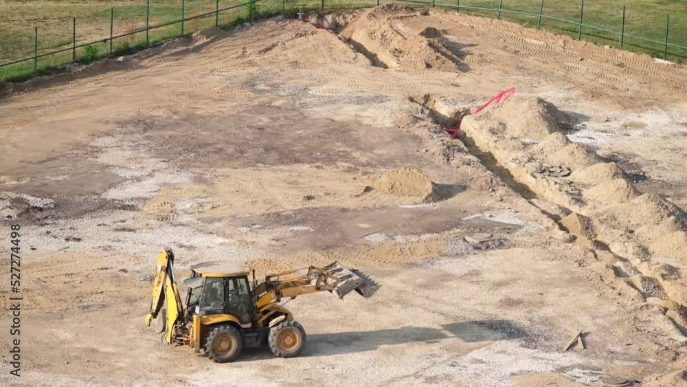 Bulldozer with a raised bucket rides on a construction site. Bulldozer with a raised bucket rides on a construction site.