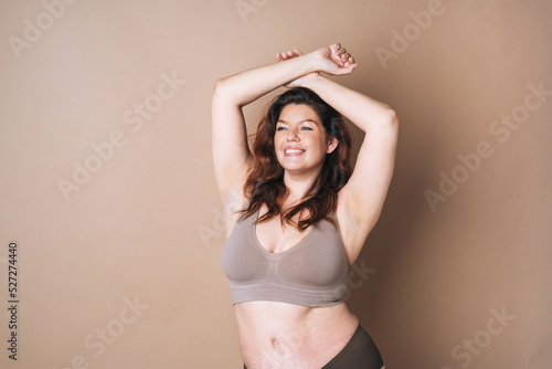 Foto Portrait of self loving woman plus size in underwear on beige background, body l