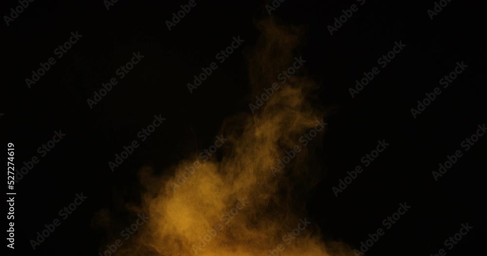 Powder particles explode from the bottom up on a black background. The dust flies in different directions. Powder particles explode from the bottom up on a black background. The dust flies in different directions.