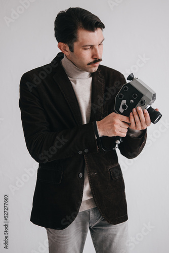 a young man in jeans and a jacket poses against a white wall in the studio.