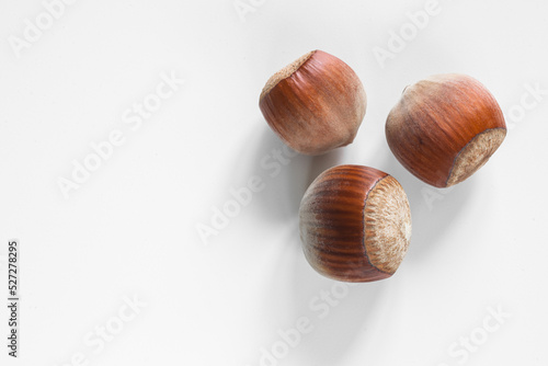 Three unopened hazelnuts against white background