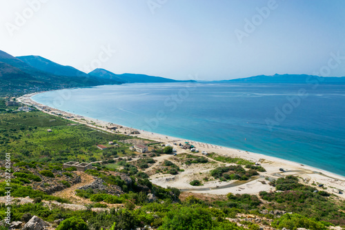 View from the top of the long sandy pebble Borsh beach. Albania. Greek Corfu or Kerkyra island at background. Ionian Sea.