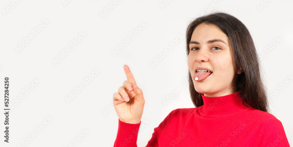 A woman in red with pills on her tongue points her finger at a place for text A woman in red with pills on her tongue points her finger at a place for text