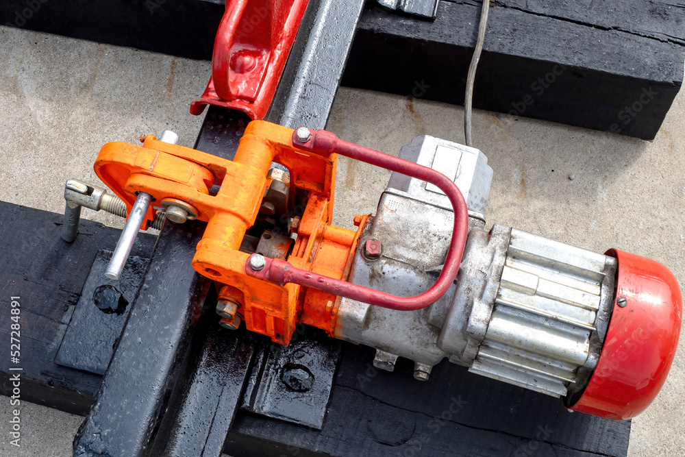 Rail drilling machine. Equipment for installation of railway tracks. Electric rail drilling machine close-up. Process of drilling hole in rail. Sale of equipment for maintenance of railway tracks Rail drilling machine. Equipment for installation of railway tracks. Electric rail drilling machine close-up. Process of drilling hole in rail. Sale of equipment for maintenance of railway tracks