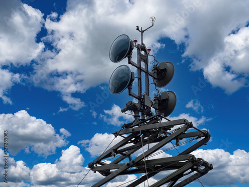 Satellite equipment. Mobile communication tower on background sky. Detailed satellite tower. Equipment for satellite communications. Radar instruments in front of clouds. Communication technologies