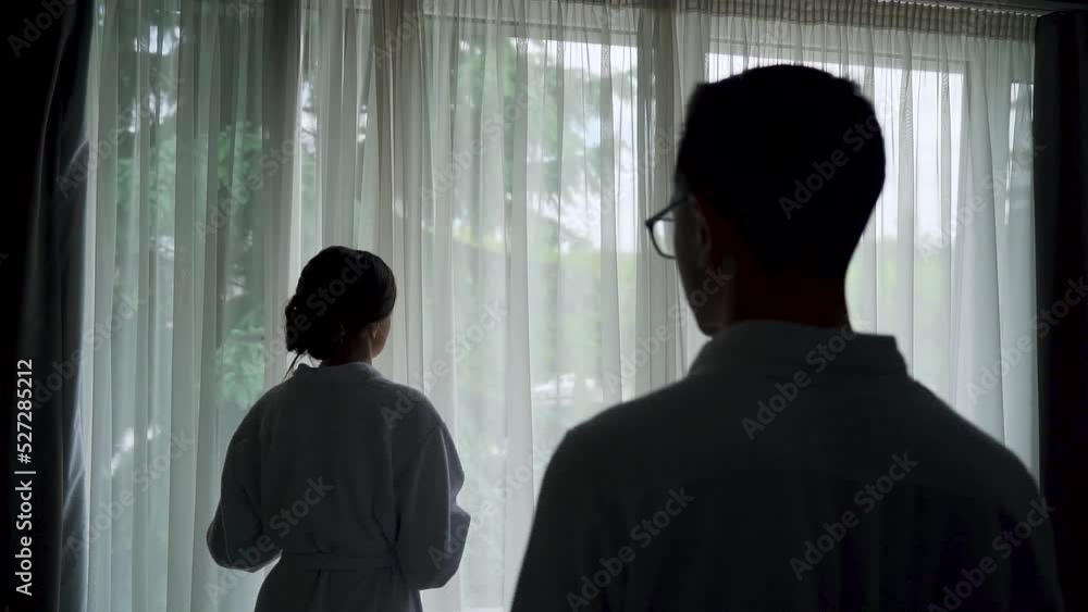 Silhouette of couple in the hotel behind window kissing. Cup of coffee in hands Silhouette of couple in the hotel behind window kissing. Cup of coffee in hands
