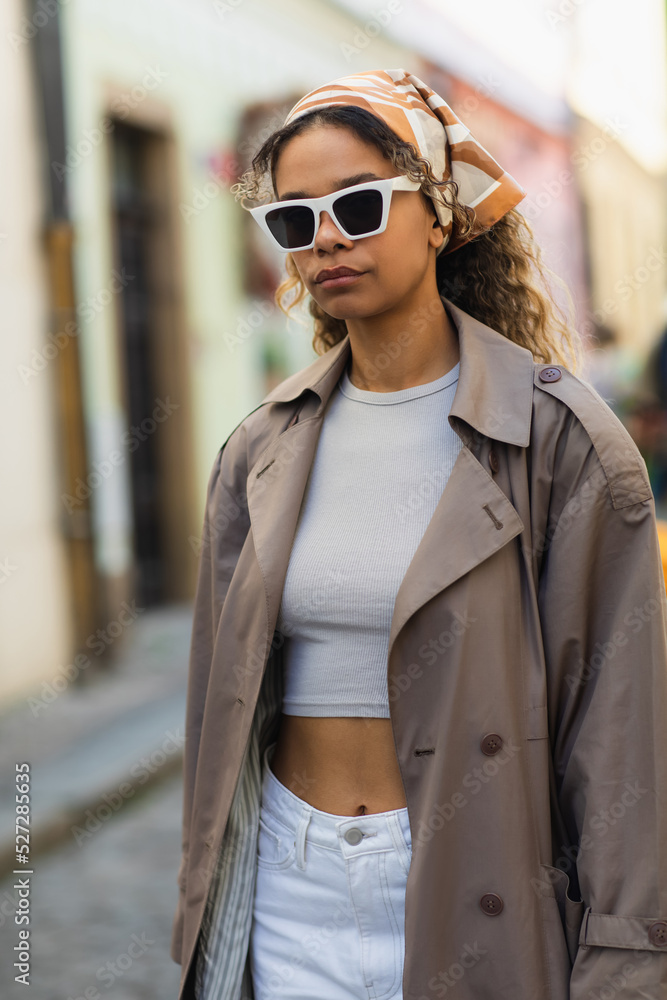 african american woman in headscarf and stylish sunglasses on street in prague.