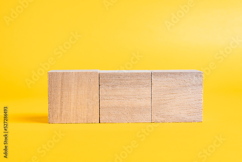 Fototapeta Naklejka Na Ścianę i Meble -  Three wooden cubes on yellow background, Editable, Static object