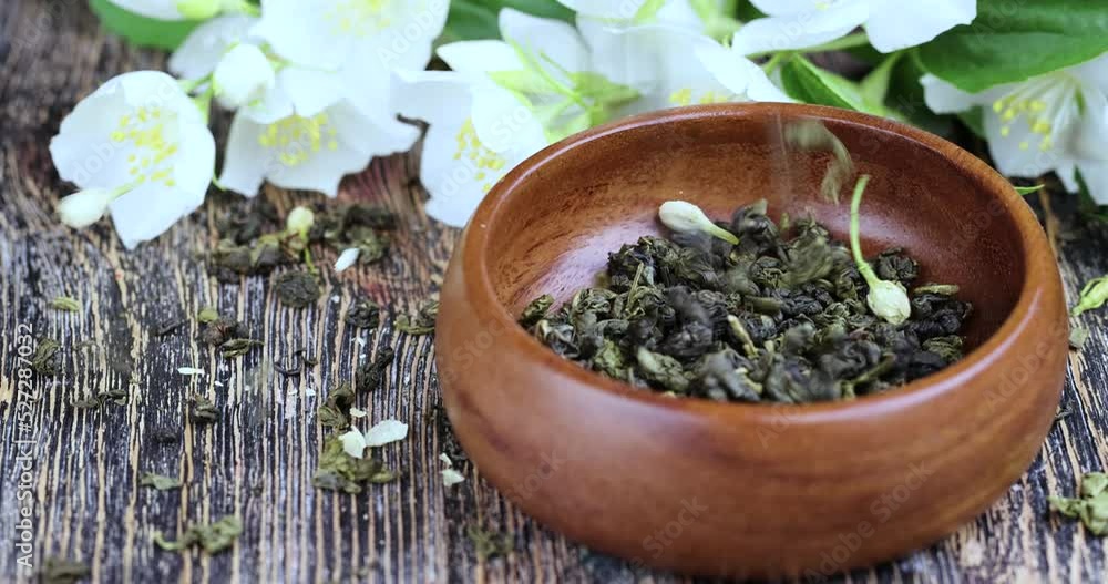 Sprinkle dry green tea with jasmine on the table, dried tea leaf for brewing green tea with jasmine flavor Sprinkle dry green tea with jasmine on the table, dried tea leaf for brewing green tea with jasmine flavor