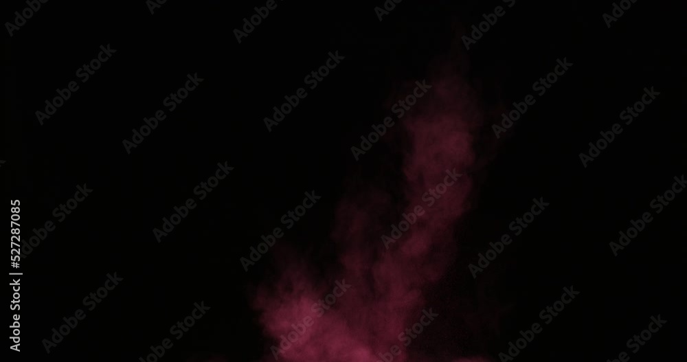 Powder particles explode from the bottom up on a black background. The dust flies in different directions. Powder particles explode from the bottom up on a black background. The dust flies in different directions.