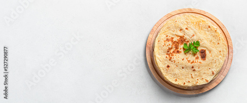 Chapati, traditional tortillas with fresh parsley on a gray background. Indian flatbreads. Top view, horizontal