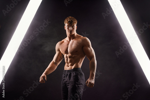  The torso of attractive muscular male body builder on black background. photo