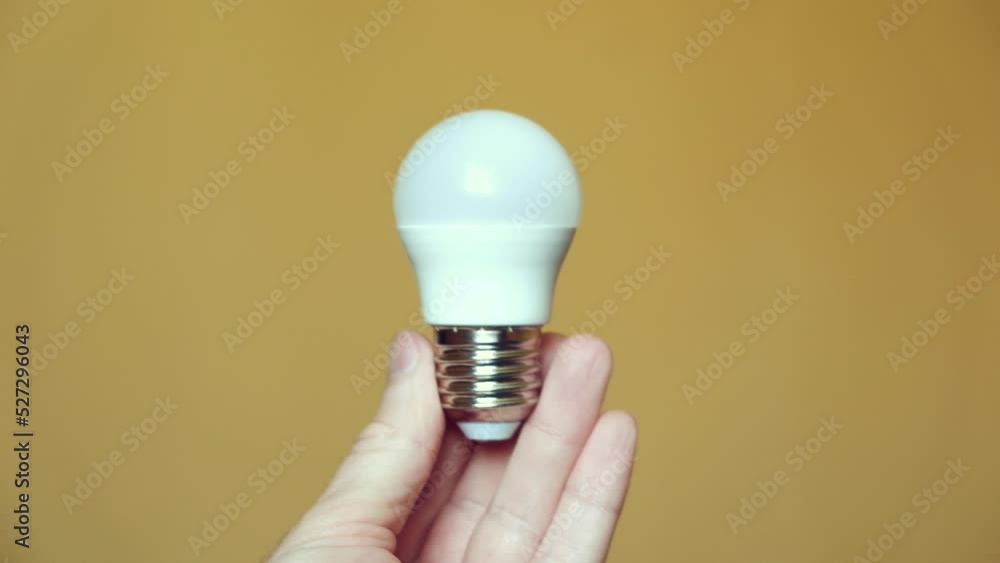 Light bulb in hand on a yellow background. light and electricity concept Light bulb in hand on a yellow background. light and electricity concept