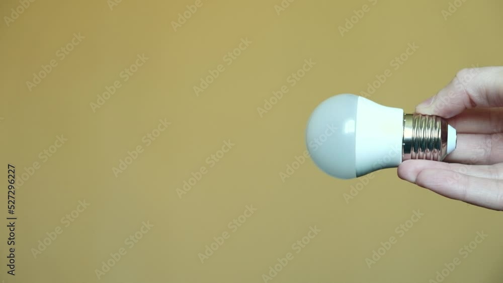 Light bulb in hand on a yellow background. light and electricity concept Light bulb in hand on a yellow background. light and electricity concept