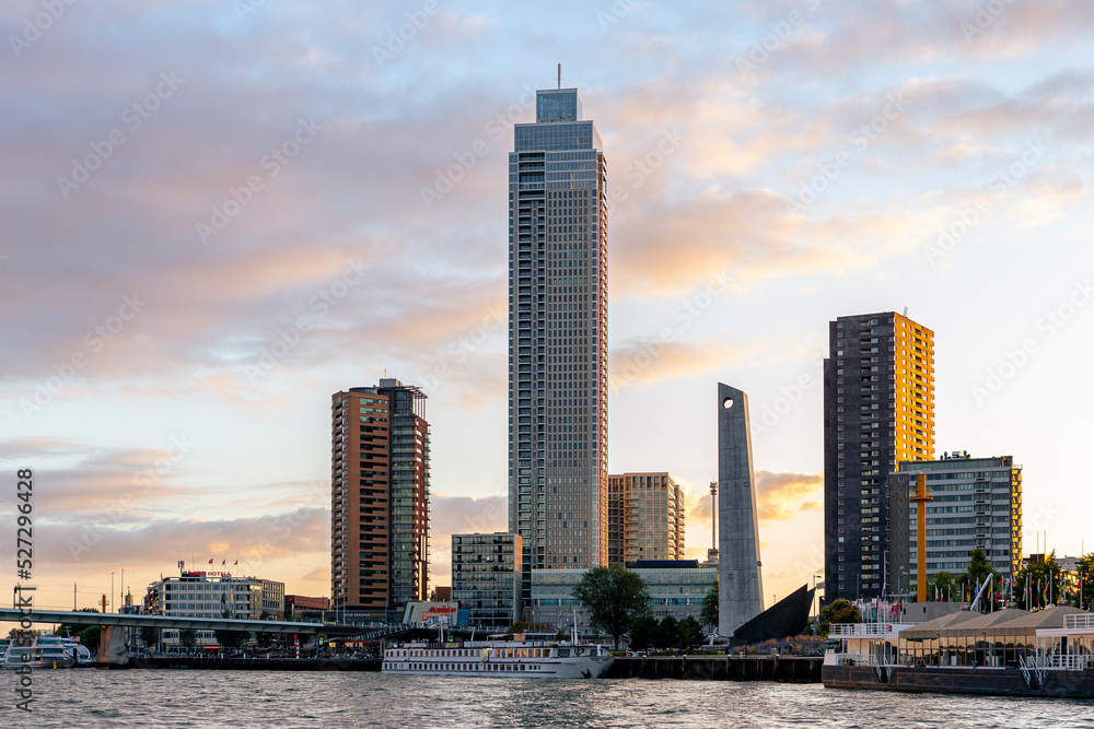 Cityscape of Rotterdam at sunset with old and new buildings against a clear colourful sky