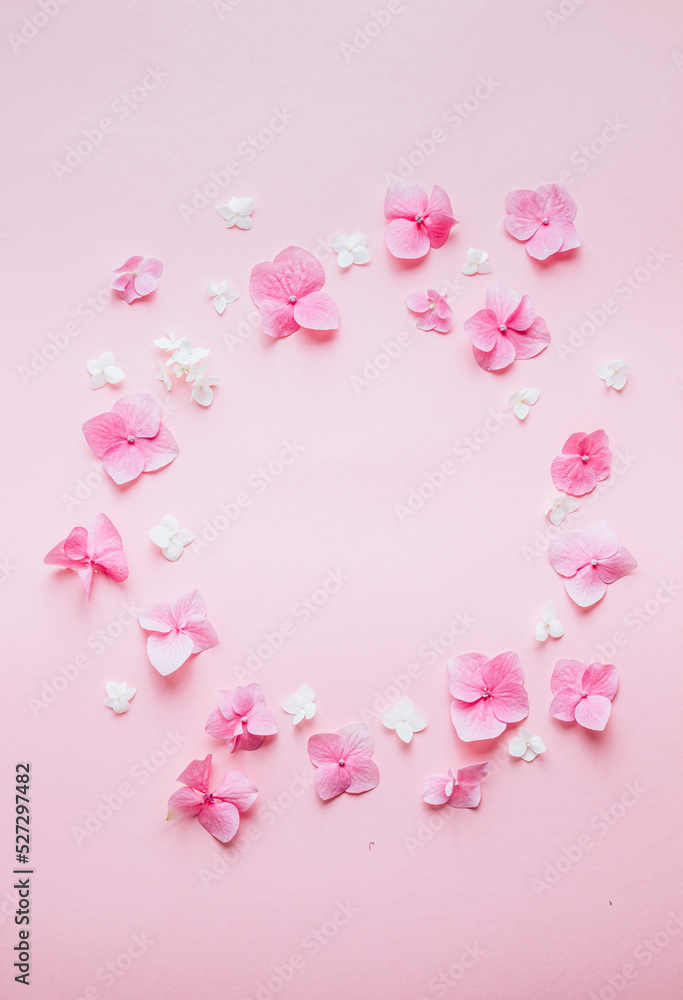 Valentine's Day background. Frame made of pink flowers, hearts on pastel pink background. Valentines day concept.
